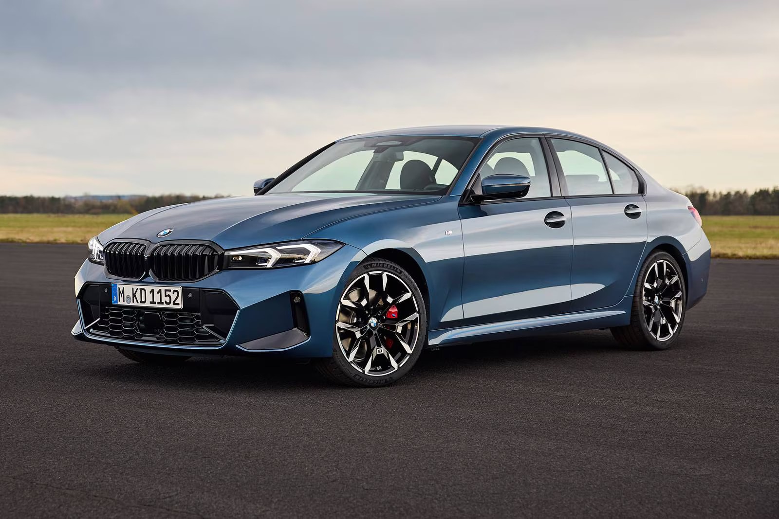 A blue bmw 330i sedan sitting parked.
