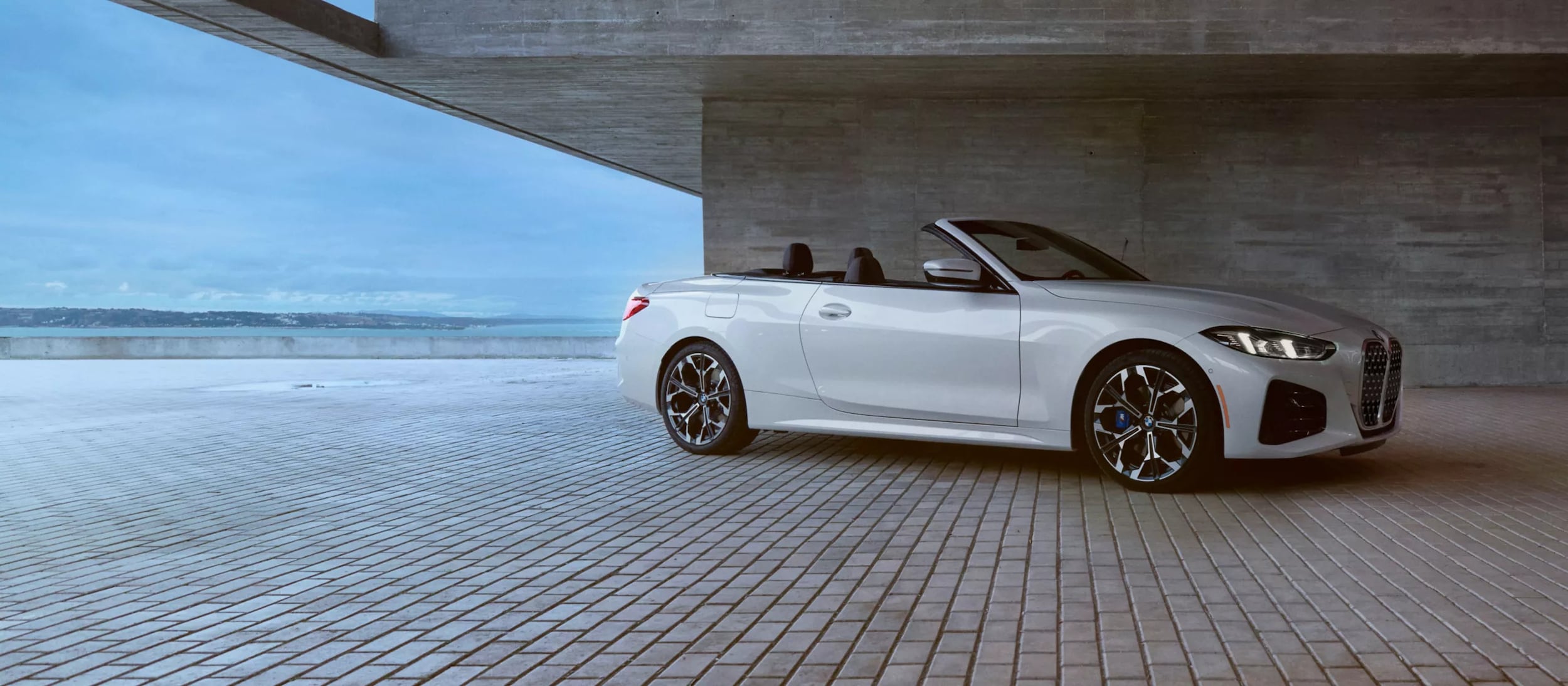 A white bmw 4 series convertible sitting parked.