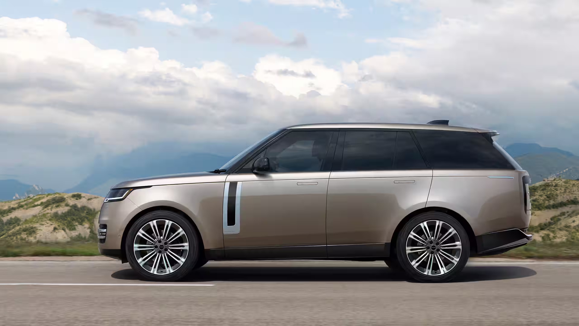A brown range rover driving on the road.
