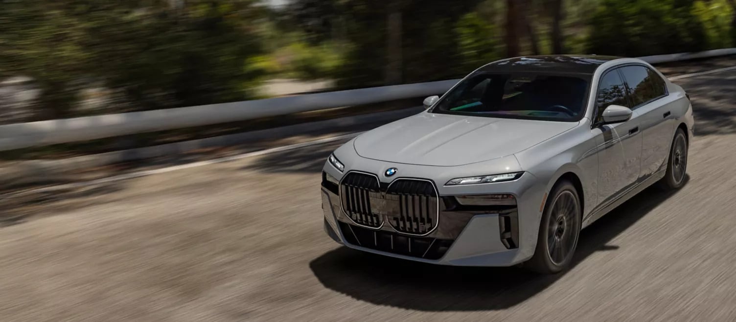 A bmw 7 series driving on the road.