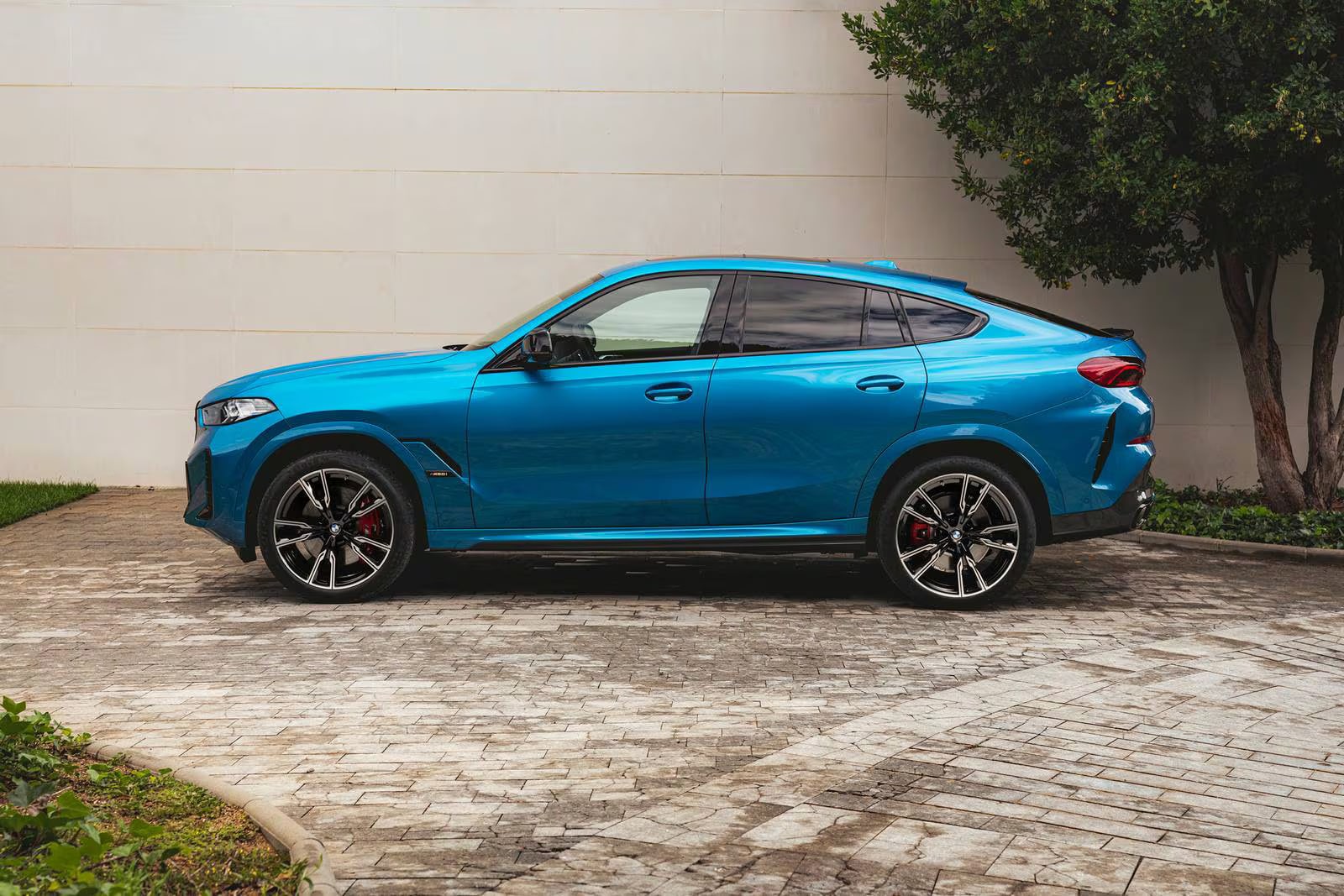 A blue bmw x6 sitting parked.