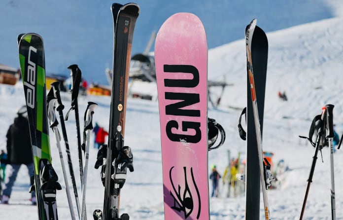 Pink%20snowboard%20and%20skis%20standing%20upright%20on%20snowy%20slope.PNG