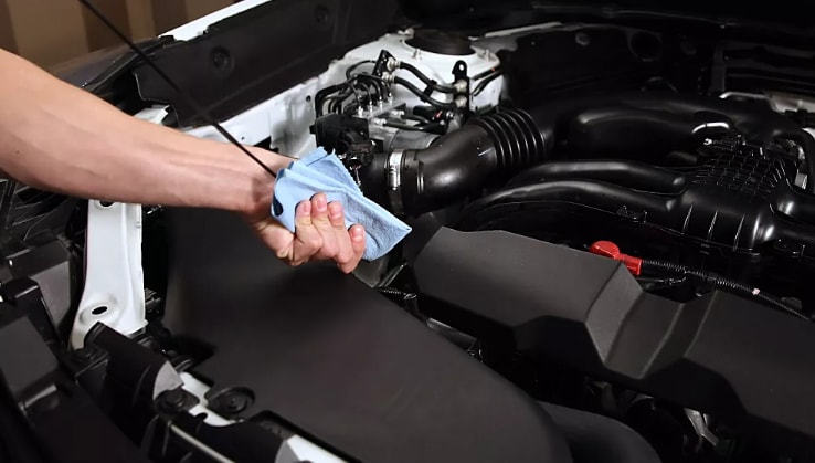 Technician checking oil level with dipstick during oil change