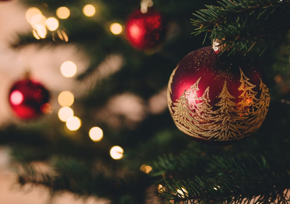 Holiday ornament on a Christmas tree with warm lights