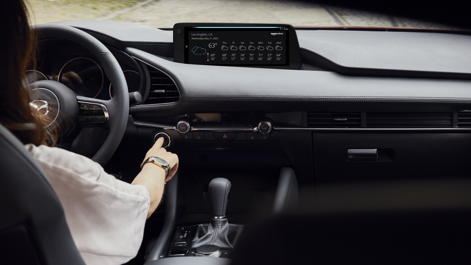 Driver behind the wheel of a Mazda sedan