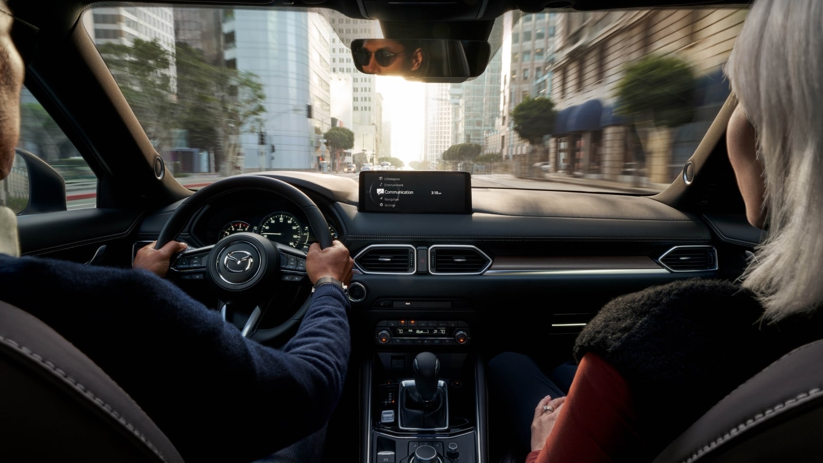 Driver behind the wheel of a vehicle with Mazda safety features