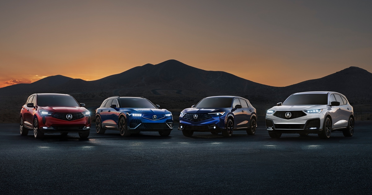 Line-up of Acura SUV models parked at night with their headlights on.