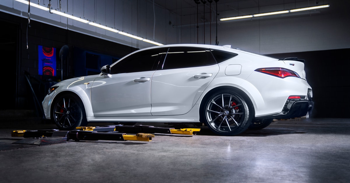 a 2024 Acura Integra in the platinum white pearl color awaiting service at a service center.