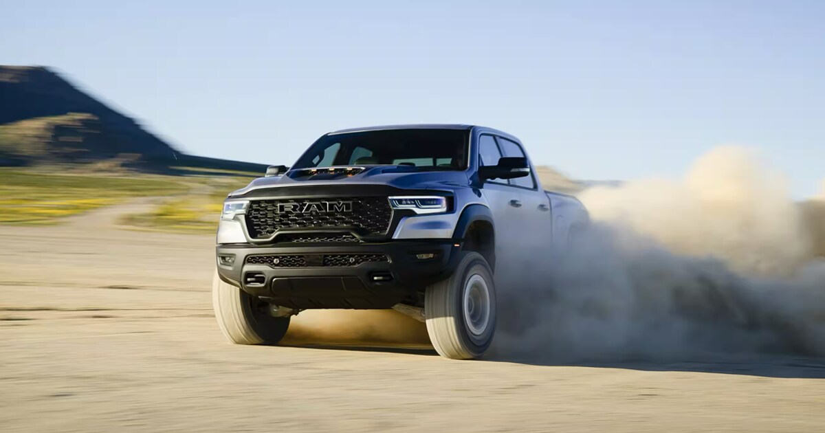 The Ram 1500 driving off-road leaving a trail of dust behind it.