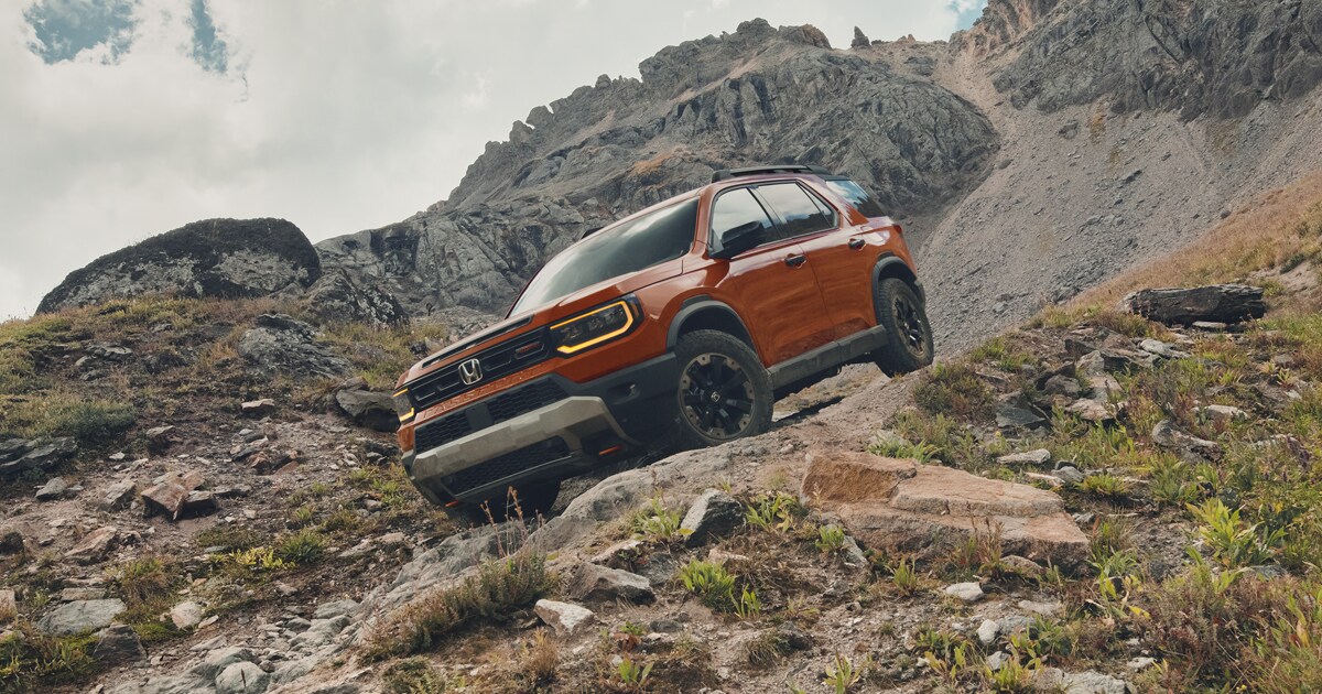 A 2026 Honda Passport driving off-road down a hill on rough terrain.