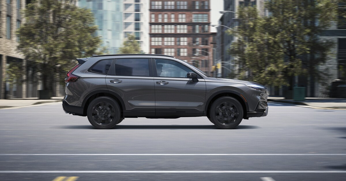 A Honda CR-V SUV driving past an intersection in a city
