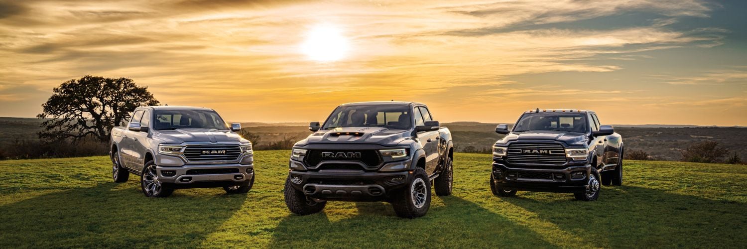 three Ram 1500 pickup trucks parked on a hill