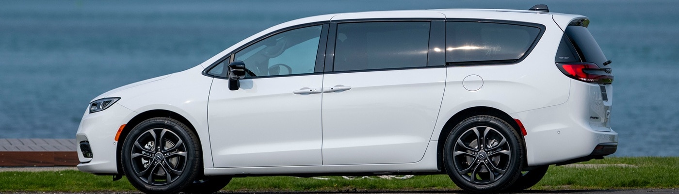 White Chrysler Pacifica Van parked by a waterfront