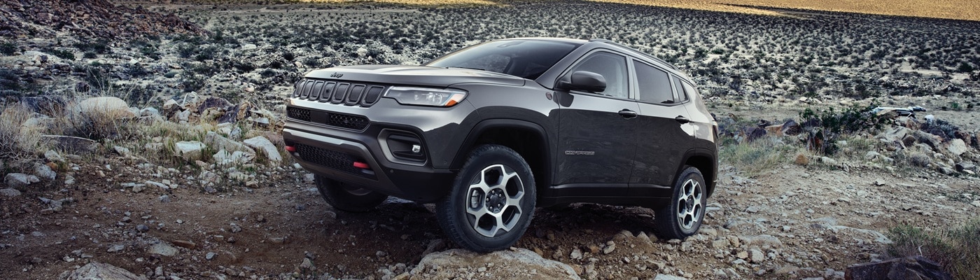 Grey Jeep Compass climbing up a hill