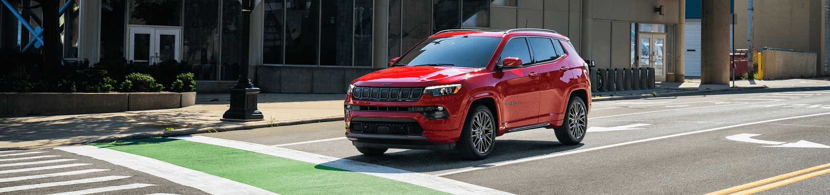 Jeep Compass stopped at a traffic light while driving in the city - Jeep Dealer Peru IN