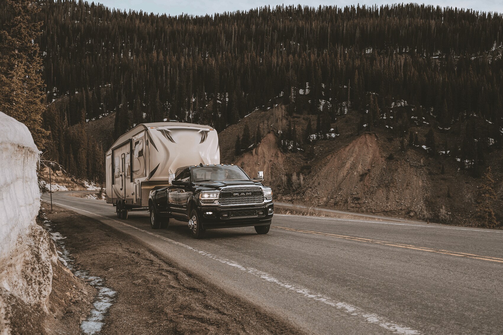 Ram truck towing a camper on mountain road