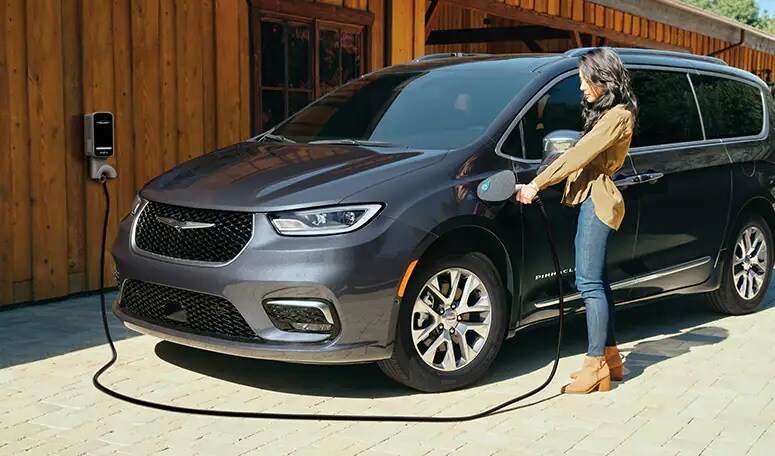 Family having fun with 2 children and electric vehicle in the background