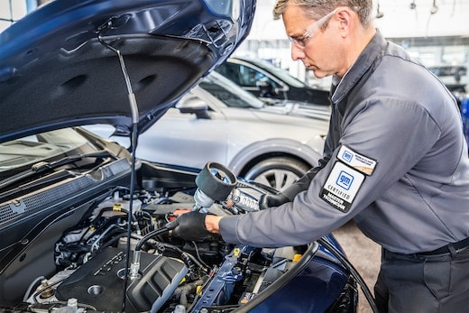 Technician performing an oil change a Chevrolet vehicle