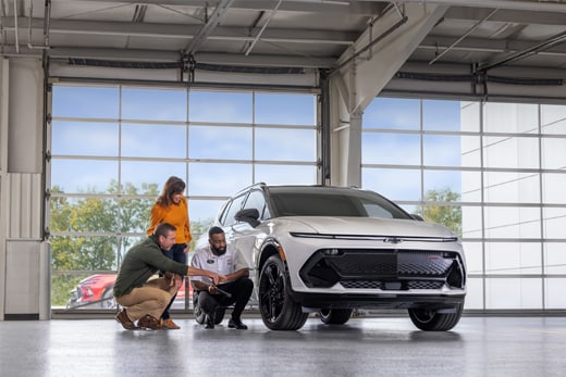 Customers discussing shocks and struts with their service advisor in the service drive.