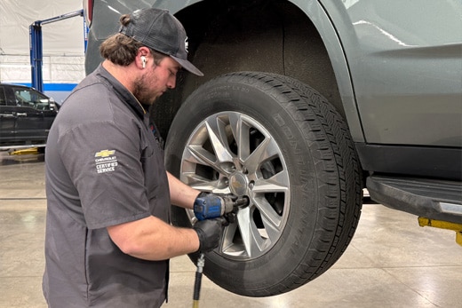 A Certified Service Technician rotating tires at Guaranty Chevrolet