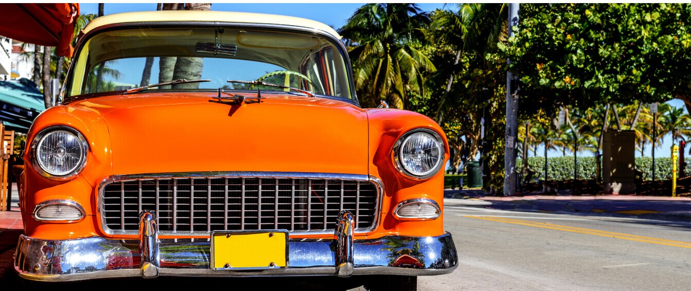 Close-up shot of a classic car in mint condition parked on a sunny Florida street.