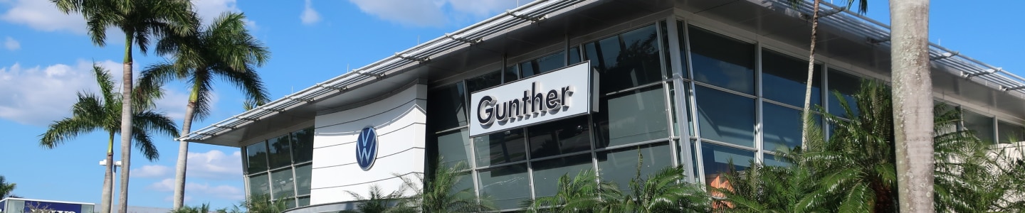 Gunther Volkswagen dealership building with VW logo and palm trees