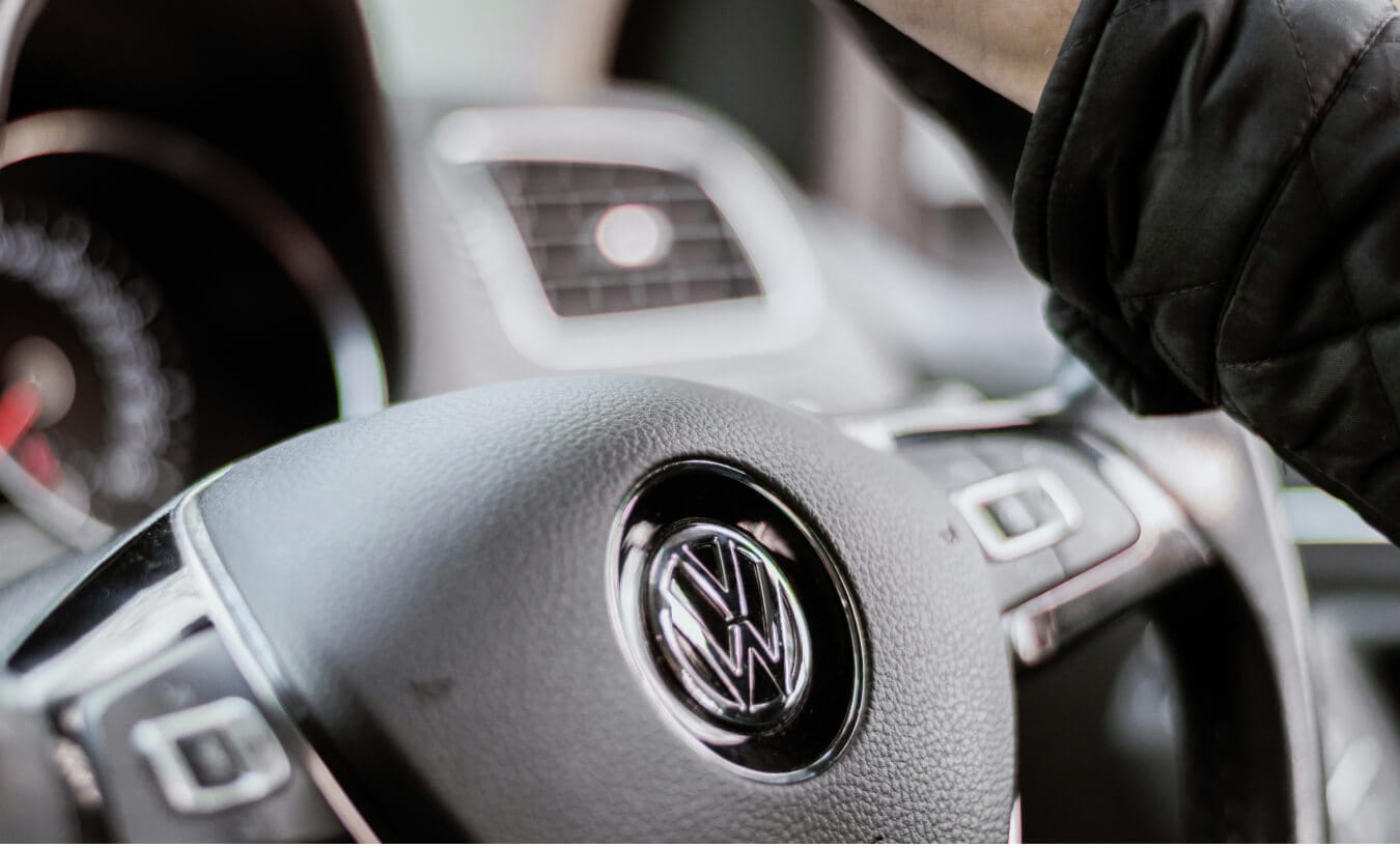 Volkswagen Tiguan SE interior in Titan Black Leatherette with leather steering wheel showing dashboard air vent.