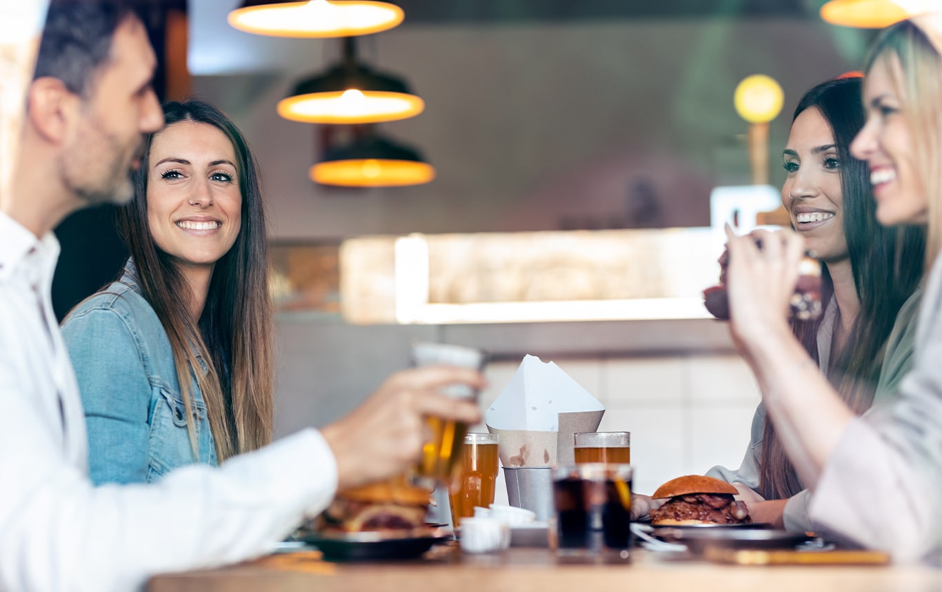 Haddad Hyundai Dealership near North Adams, MA | Group of friends smiling and eating food together at a resturant  