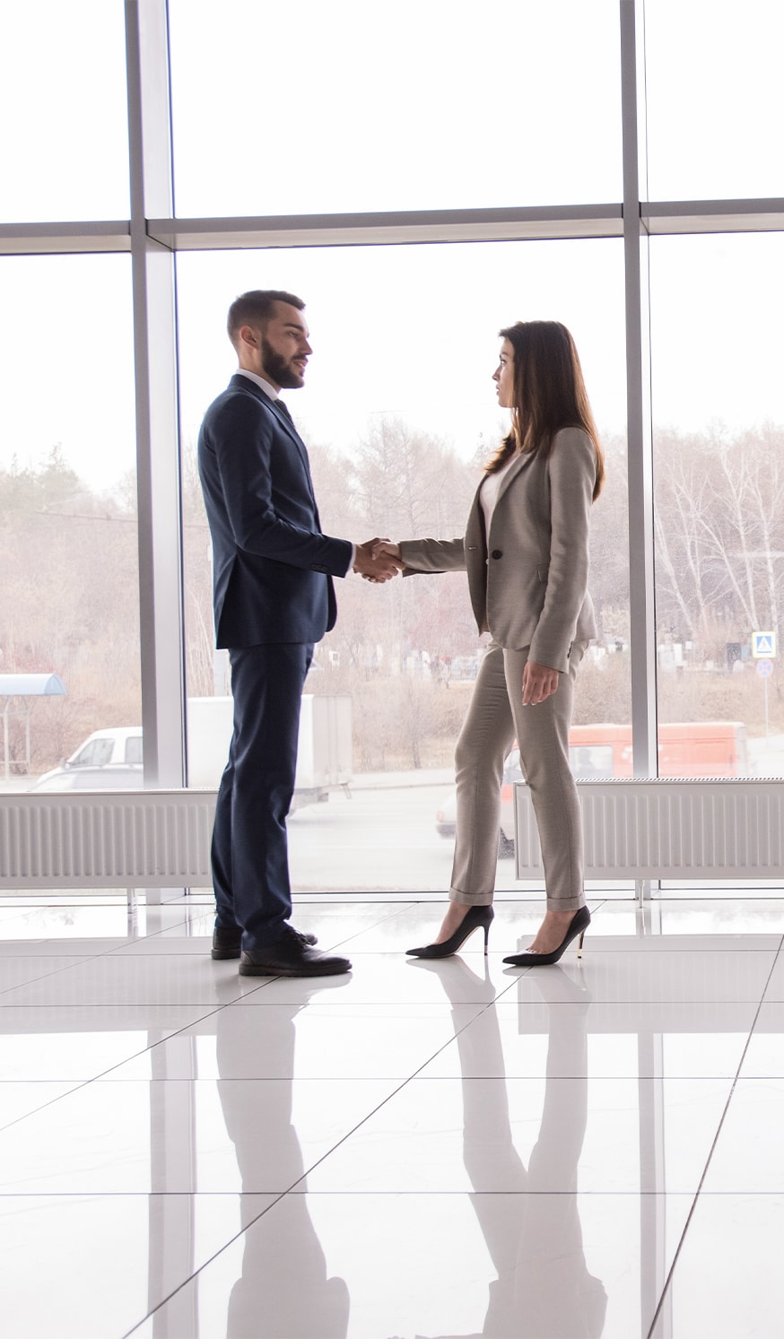 Haddad Hyundai Dealership near North Adams, MA | Man in a black suit on the left and shaking hands with a woman on the right with a beoge suit 