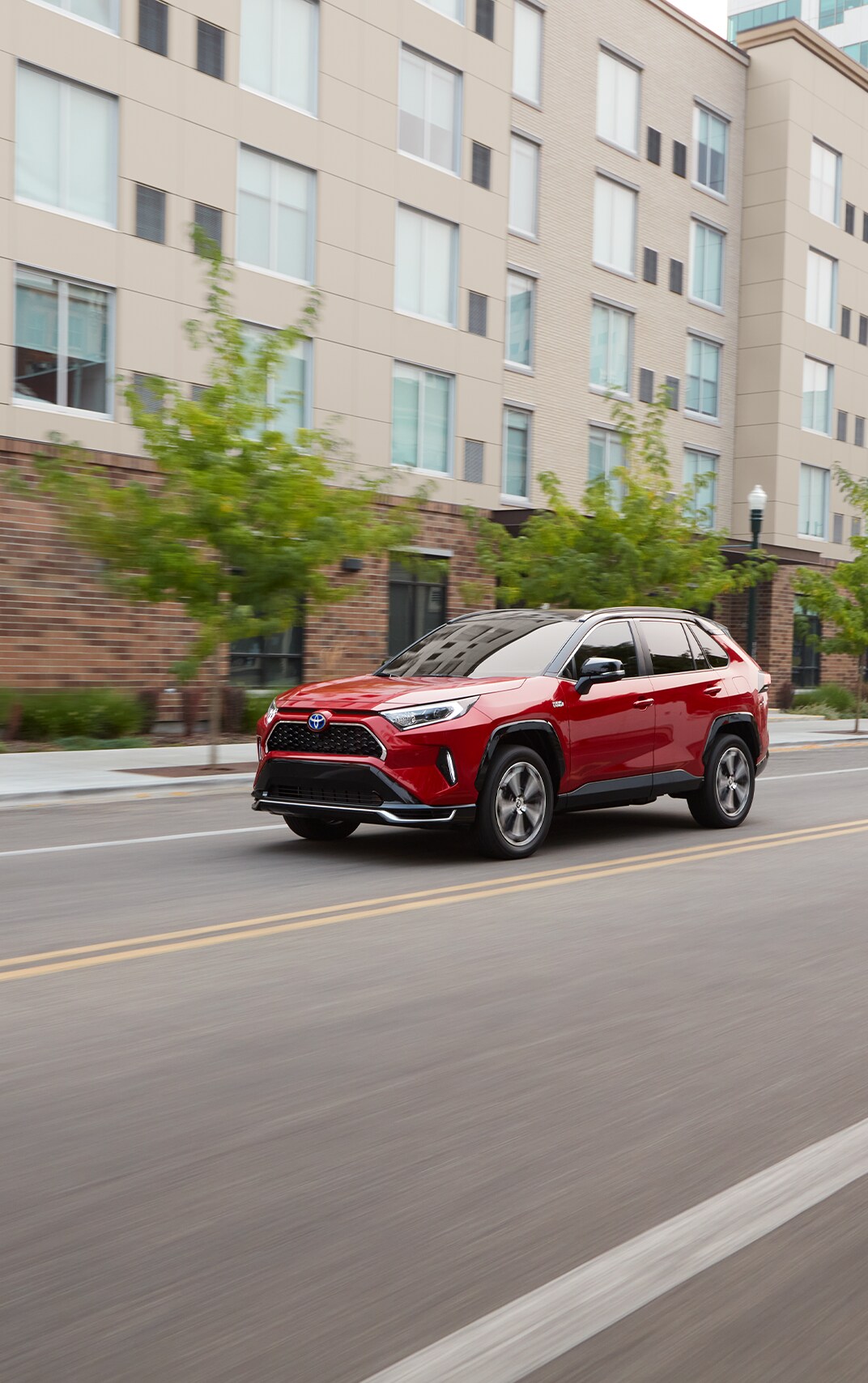 Haddad Toyota Dealership near Great Barrington, MA | Red 2022 Toyota RAV4 driving down empty city streets