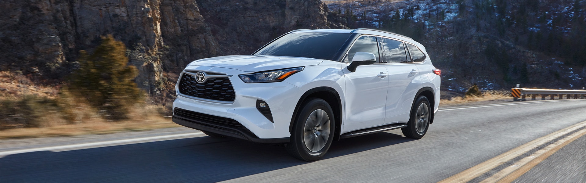 Haddad Toyota is a Toyota Dealership near Pittsfield, MA | White Toyota Highlander Driving on Rural Mountain Road