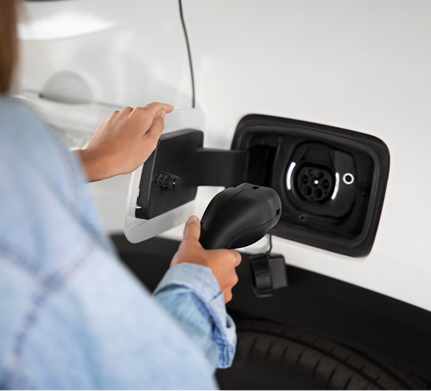 How to prepare your home for your new Electric Vehicle at Haddad Toyota in Pittsfield, MA | Person about to connect her car charger into car port 