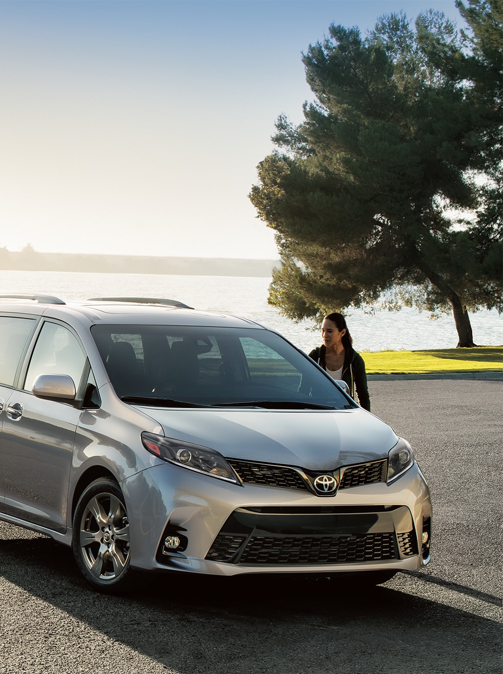 Haddad Toyota Dealership near Williamstown, MA | Woman looking at a parked Silver Toyota Sienna by the lake