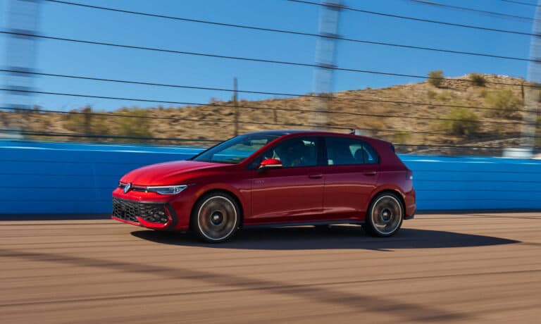 2025 Volkswagen Golf GTI driving fast on bridge