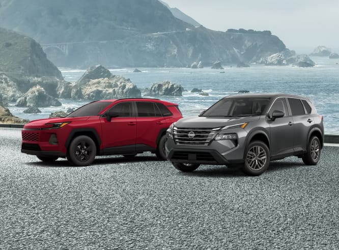 Red Toyota RAV4 and gray Nissan Rogue parked side by side on a coastal road.