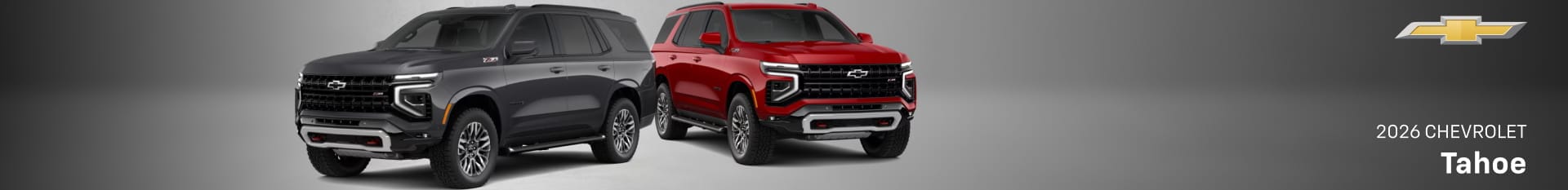Two 2026 Chevrolet Tahoe SUVs in dark gray and red, shown in front three-quarter views with Chevrolet branding.