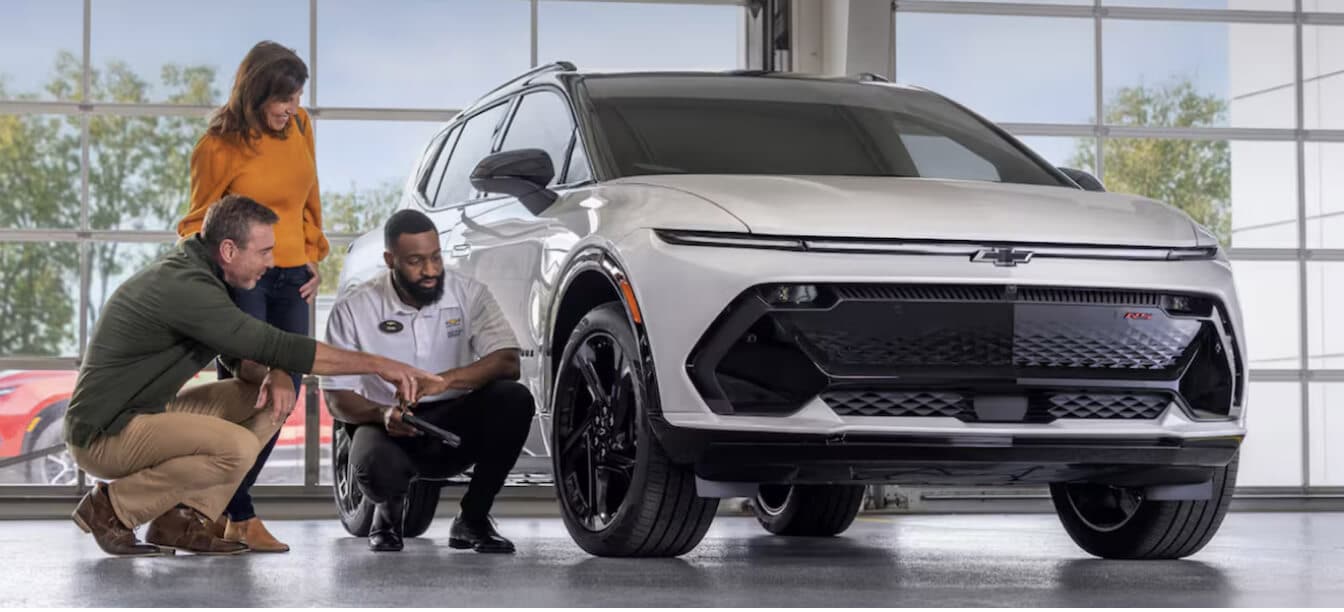 Chevrolet Blazer EV RS exterior in Iridescent Pearl Tricoat with advisor displaying tire tread depth inside a service drive.
