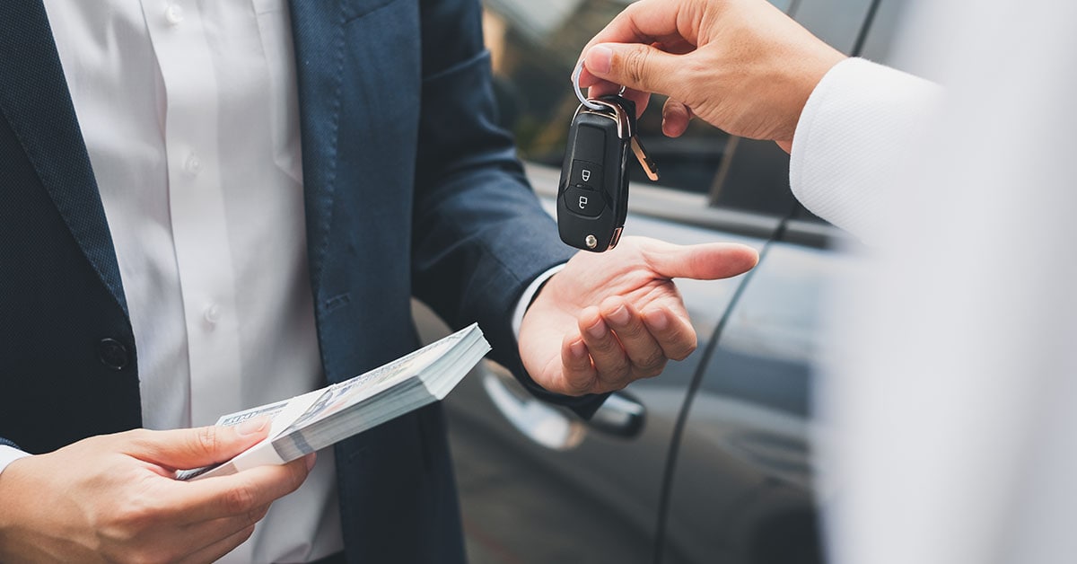 Person handing car keys to a customer during a car trade-in