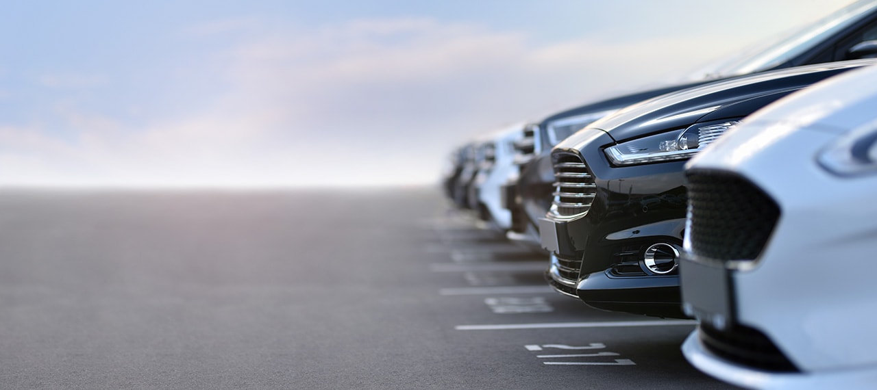 cars lined up in a dealership inventory lot