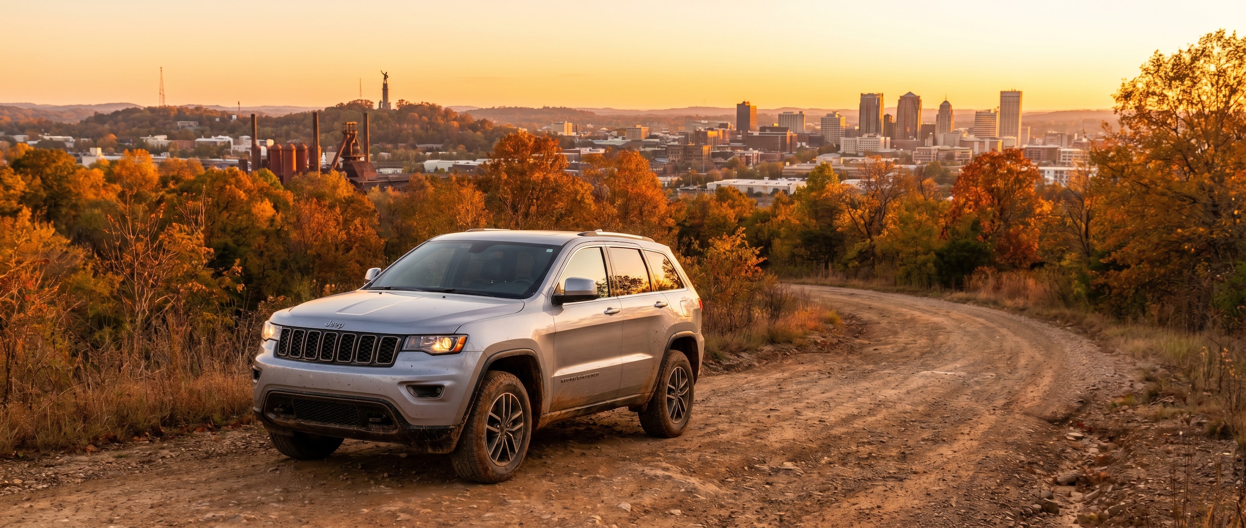 Jeep Grand Cherokee driving through Birmingham AL hills showcasing all-terrain capability