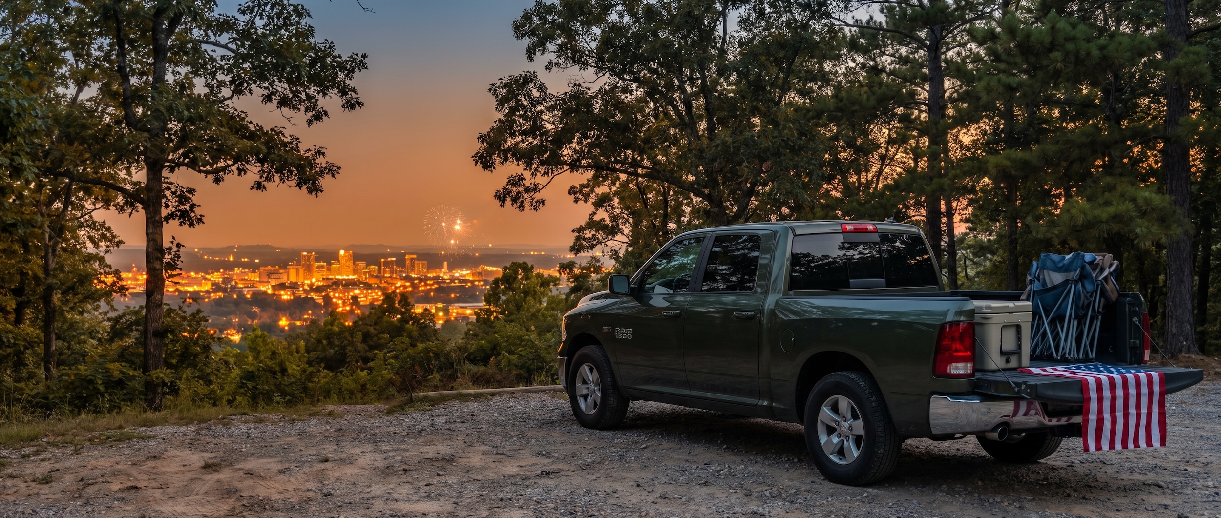 Jeep Grand Cherokee packed for Fourth of July fireworks weekend parked near Birmingham Alabama skyline at dusk