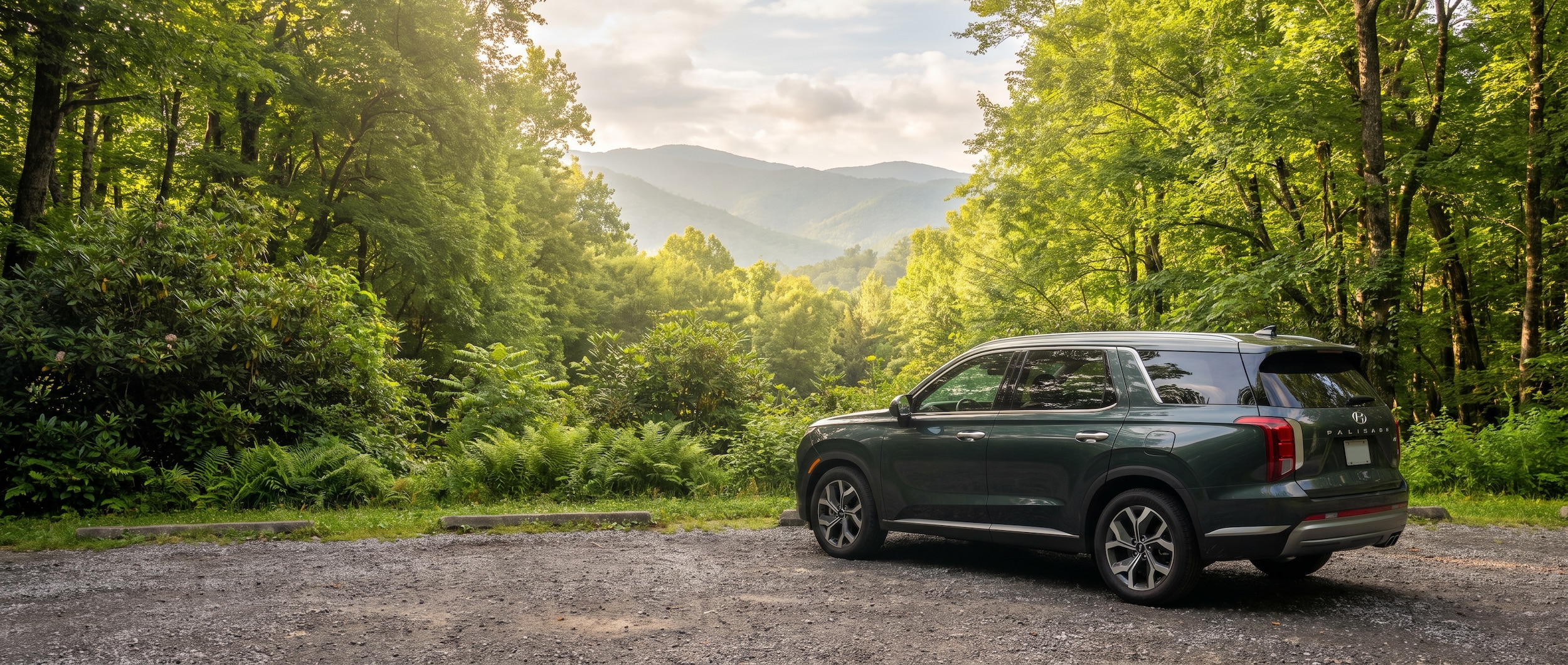 A 2026 Hyundai Palisade in a scenic mountain parking area with the Great Smoky Mountains ridgeline in the background, early morning light, lush green summer forest, Tennessee foliage visible, family SUV parked in a designated trailhead lot