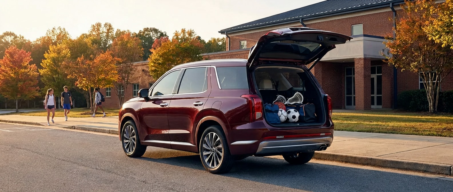2026 Hyundai Palisade Hybrid parked at a Birmingham high school during fall sports season with rear liftgate open