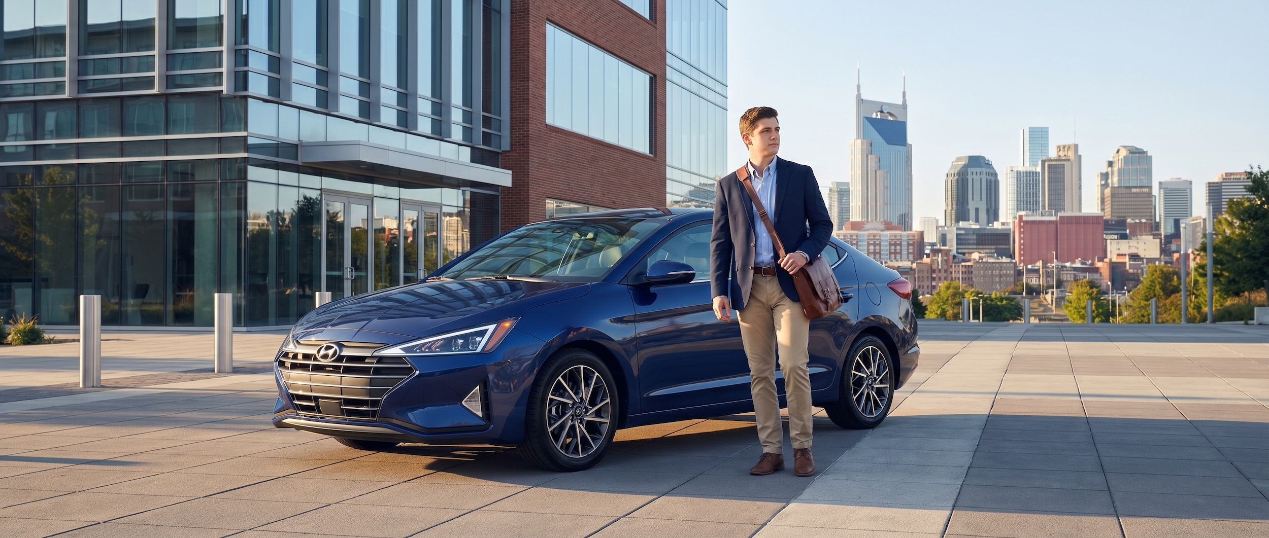A young professional in business casual attire standing next to a sleek Hyundai Elantra parked near a modern Nashville office building on a bright summer morning, with a laptop bag over their shoulder and downtown skyline visible in the background.