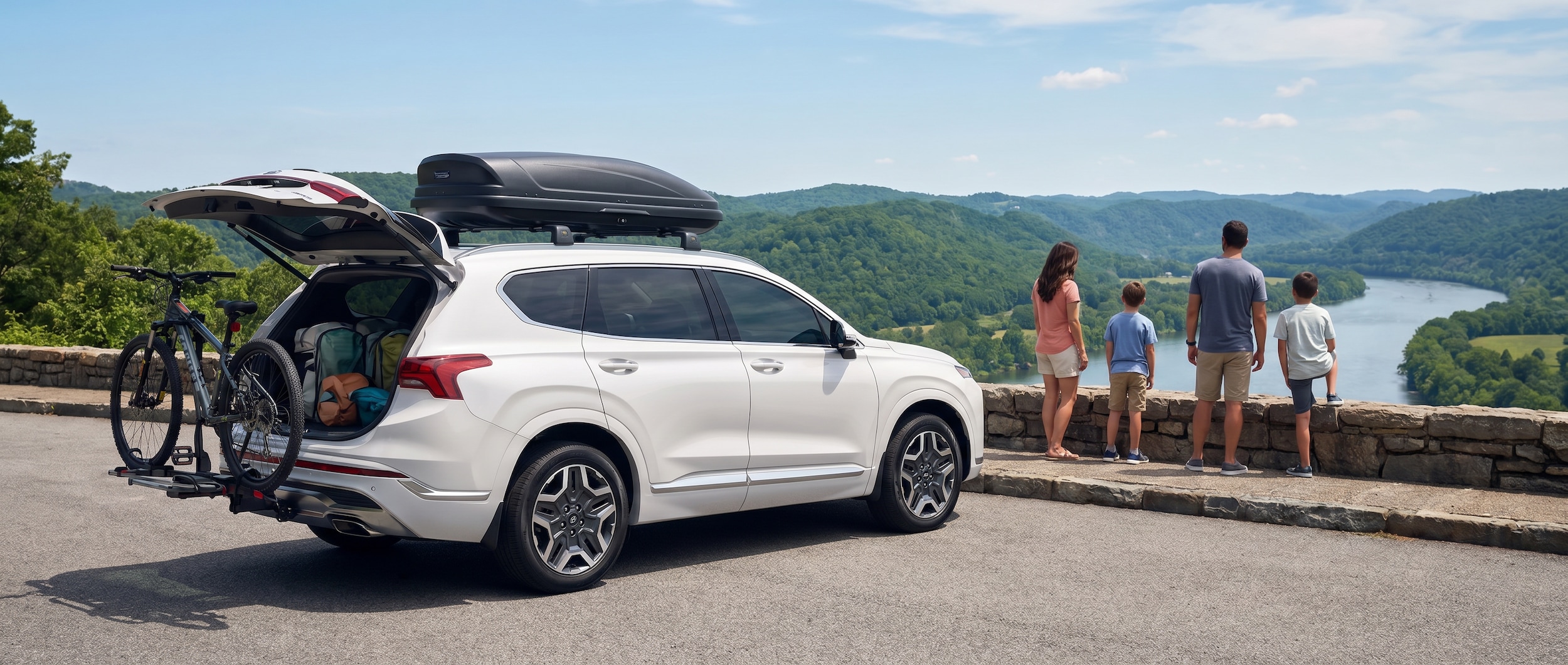A silver Hyundai Santa Fe Hybrid parked at a scenic overlook with rolling Tennessee hills and blue skies in the background, luggage visible through the rear window, suggesting a family road trip in progress.