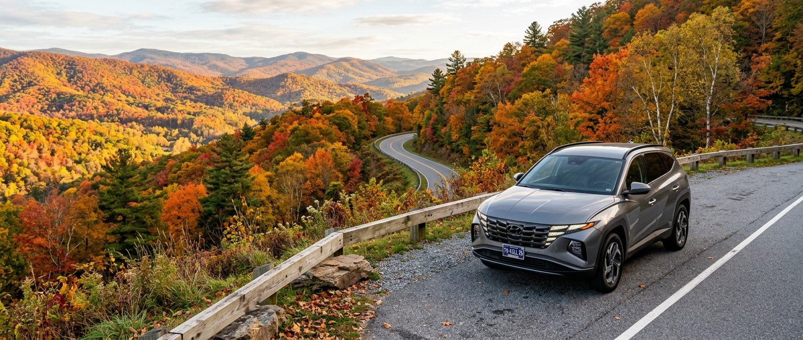 2026 Hyundai Tucson Hybrid at a Tennessee fall foliage overlook with orange and red trees lining a winding parkway road