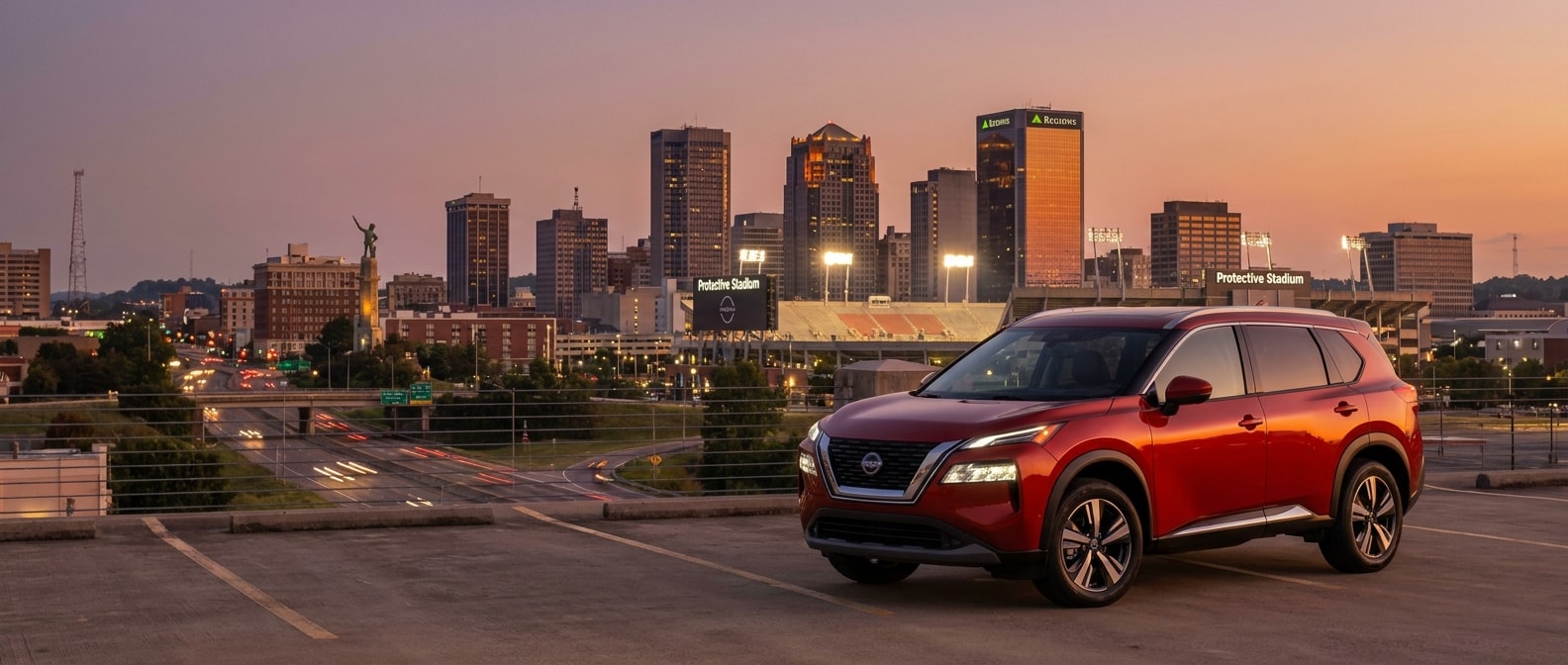 2026 Nissan Rogue parked near downtown Birmingham with stadium lights visible at dusk