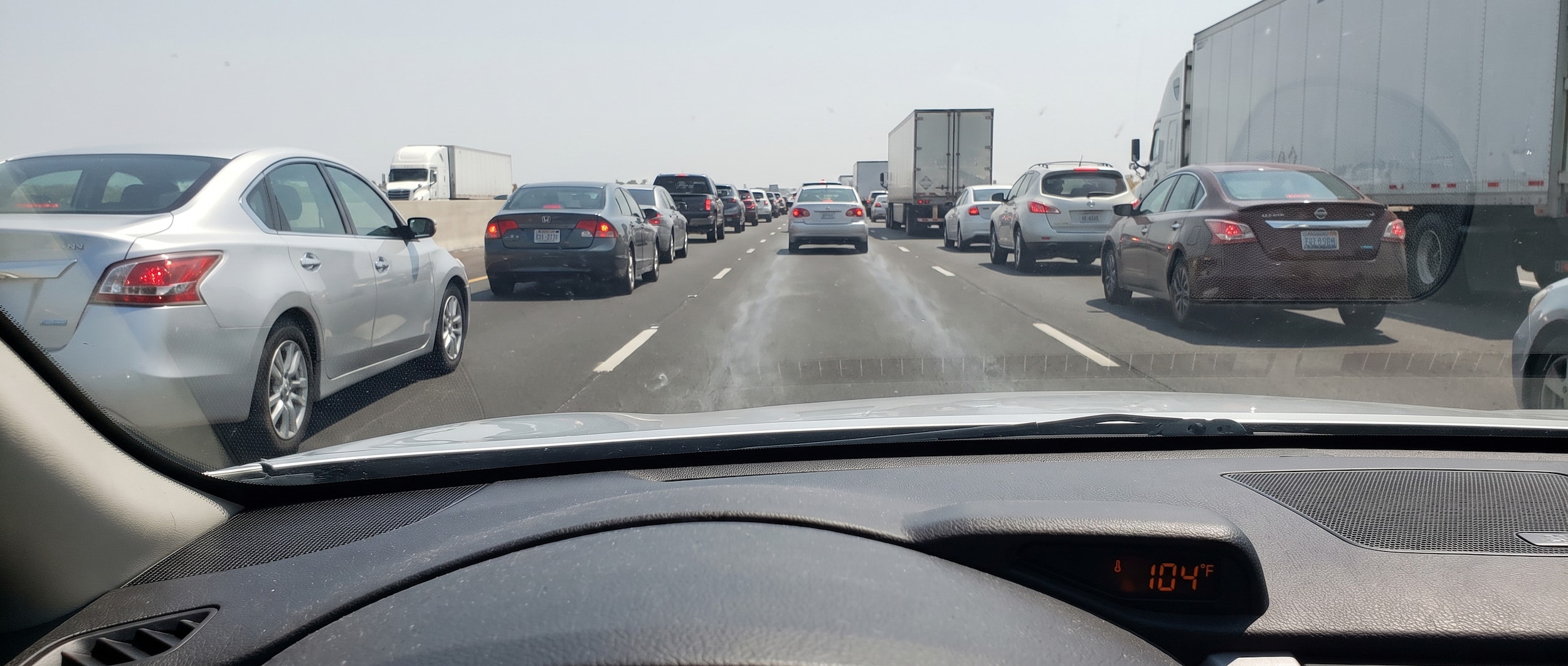 Nissan Altima stopped in Birmingham Alabama summer traffic with heat haze rising from the road