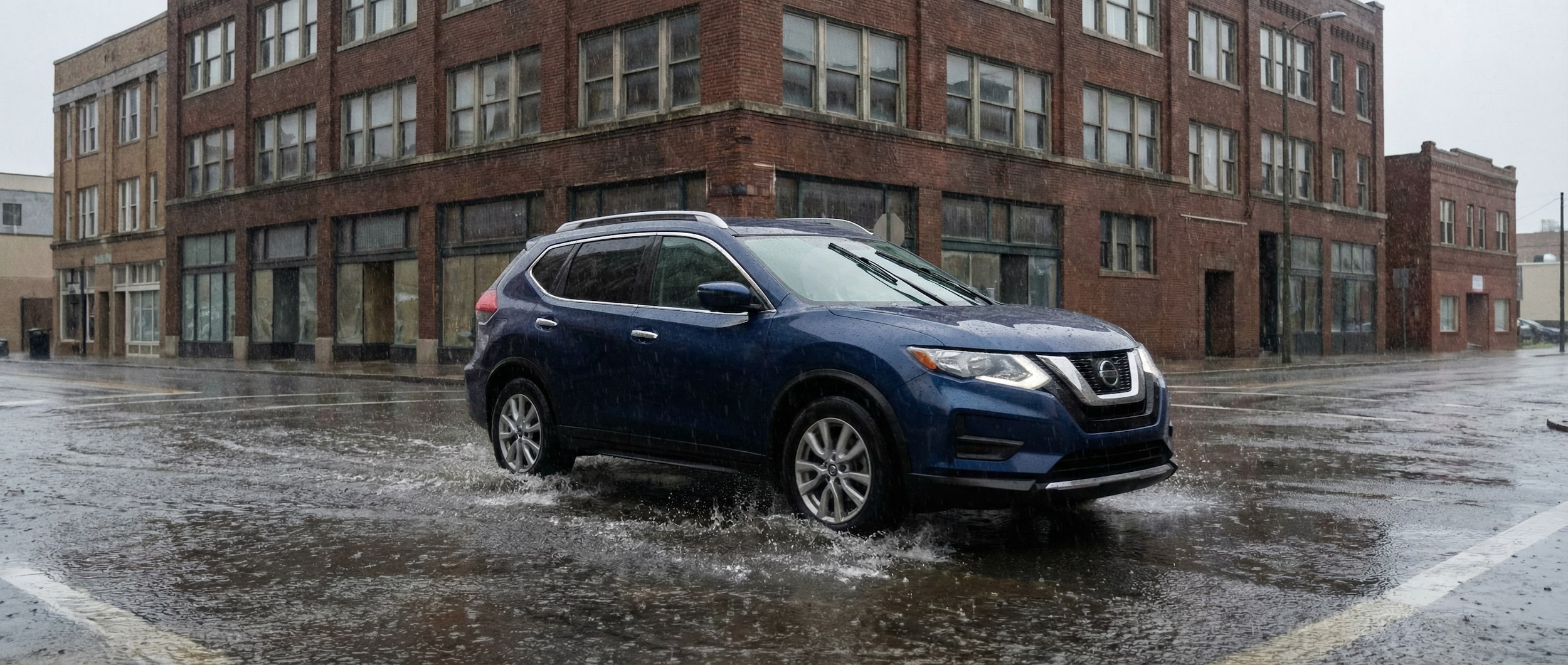 Nissan Rogue driving safely through wet Birmingham AL streets during rainstorm