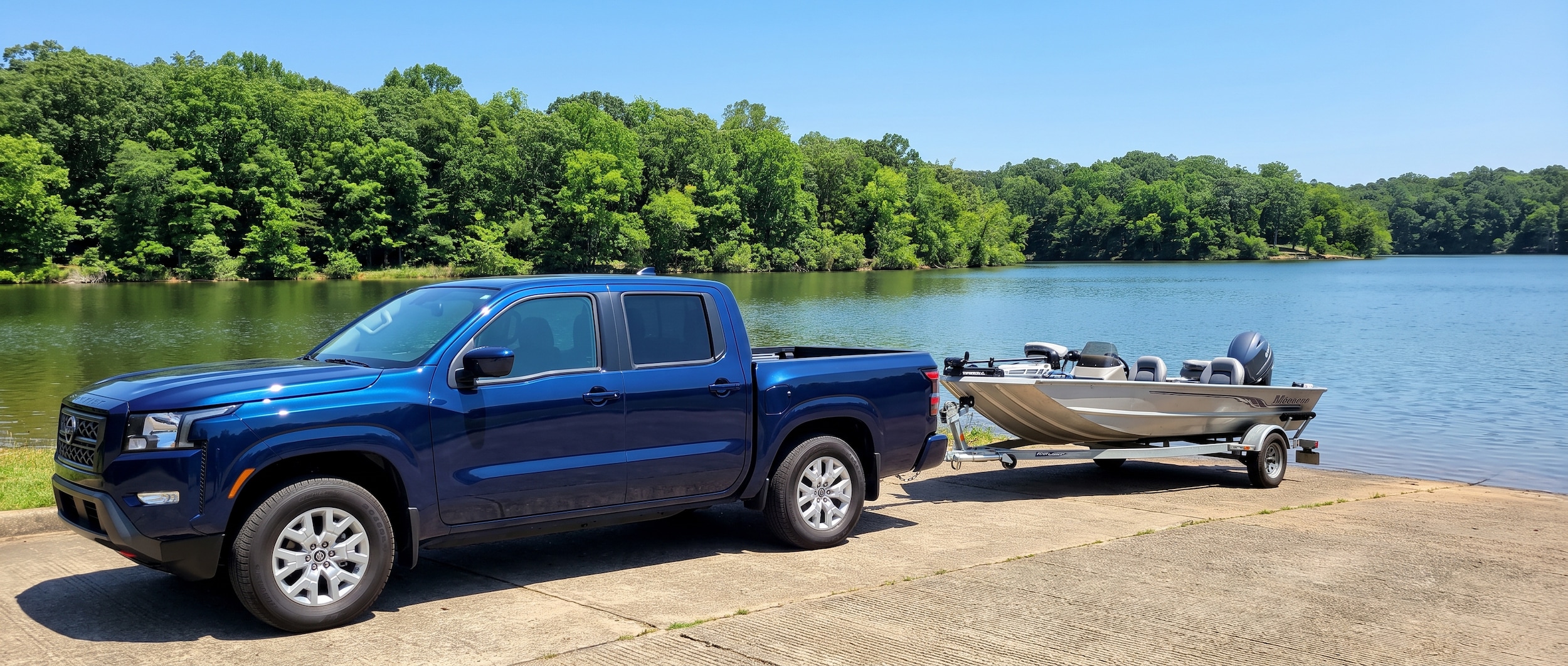 2026 Nissan Frontier Crew Cab with boat trailer at an Alabama lake boat ramp on a summer day